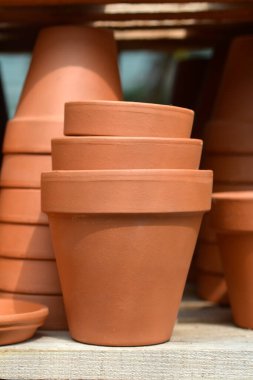 Boş terracotta saksıları olan ahşap bir raf.