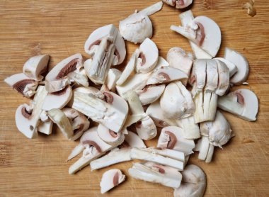 Bambu kesme tahtası ve çiğ mantar dilimleri.