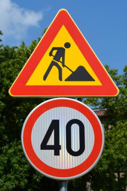 İki trafik işareti, biri yol çalışmalarını gösteriyor, diğeri de 40 km / saat hız limitini gösteriyor.