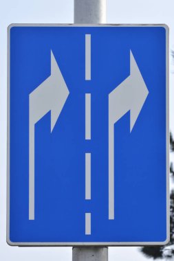 İki şeritten de sağa dönüş gösteren mavi bir trafik işareti.