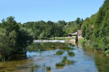 The Dobra River in Jaskovo with an old mill and small dam clipart