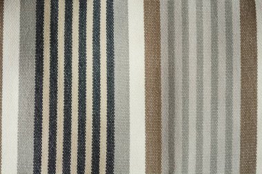 Detail of striped fabric with vertical stripes of varying widths in shades of gray, beige,and white clipart