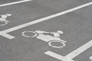 Beyaz çizgiler ve motosiklet sembolüyle işaretlenmiş bir motosiklet park yeri.