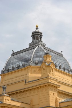 Hırvatistan 'ın Zagreb kentindeki süslü Sanat Pavyonu' nun ayrıntıları arasında heykellerle süslenmiş ve üzerinde altın bir finale sahip büyük cam bir kubbe yer alıyor.