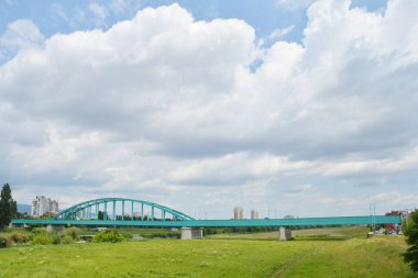 Hendrix Köprüsü olarak da bilinen Yeşil Demiryolu Köprüsü, bulutlu bir gökyüzü altında Hırvatistan 'ın Zagreb kentindeki Sava Nehri' ni kapsıyor.