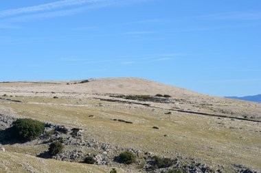 Hırvatistan 'ın Krk adasında Baska' dan Vela Luka 'ya uzanan manzaralı bir yürüyüş yolu, geleneksel kuru taş duvarları olan engebeli, kayalık bir araziden geçiyor