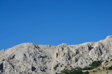 Hırvatistan 'ın Krk adasındaki Baska Körfezi' nin batı kısmındaki dağların heybetli, kayalık yamaçları.