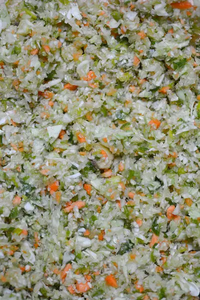 Havuç, lahana ve yeşillikler de dahil olmak üzere iyi doğranmış karışık sebzelerin yakın plan çekimi.