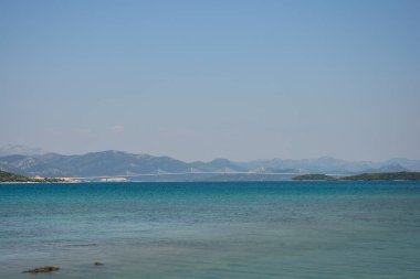 Peljesac Köprüsü, Adriyatik Denizi 'nin sakin, turkuaz sularına yayılarak Peljesac yarımadasını anakaraya bağlar.