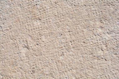 Kalıplaşmış bir taş çerçevenin yakın plan çekimi, kabataslak, yıllanmış yüzeyini ince renk değişiklikleri ve karmaşık detaylarla sergiliyor, işçiliğini ve doğal güzelliğini vurguluyor.