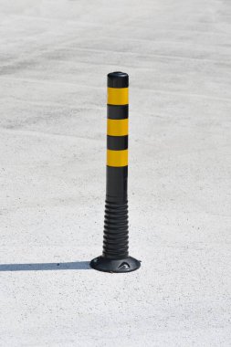Trafiği yönlendirmek ya da asfalt bir yüzeye yerleştirilmiş park yerini işaretlemek için siyah ve sarı esnek bir trafik direği.
