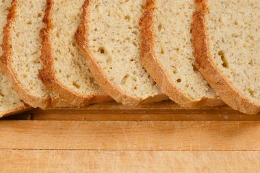 Chia tohumlu ev yapımı ekmek dilimleri ahşap bir kesme tahtasının üzerine dizilir, dokusu ve sağlıklı malzemeler sergilenir.