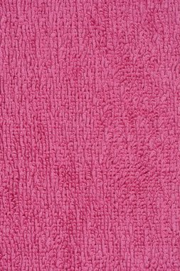 Pembe bir kumaş parçasının yakın plan çekimi yumuşak ve yumuşak doğasını vurgulayarak dokusunu, kıvrımlı yüzeyini ortaya çıkarır.