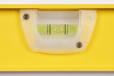 Sıvı ve hava kabarcıklarıyla dolu temiz bir plastik şişeyle sarı bir aletin yakın çekim görüntüsü.