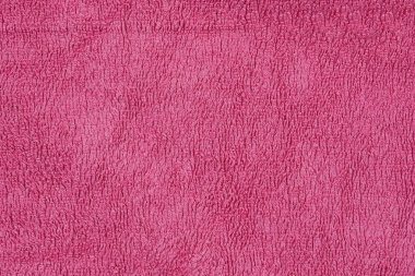 Pembe bir kumaş parçasının yakın plan çekimi yumuşak ve yumuşak doğasını vurgulayarak dokusunu, kıvrımlı yüzeyini ortaya çıkarır.