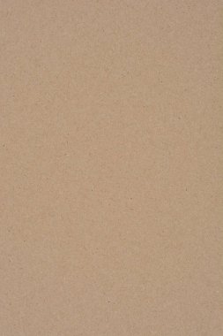 Düz kahverengi bir kağıt yüzeyin düz, yakın plan bir görüntüsü. Dokusunu ve doğal rengini sergiliyor.