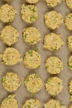 Parşömen kağıdına yerleştirilmiş çiğ soya köftelerinden oluşan, dokulu yüzeylerini ve görünür malzemelerini sergilemeye hazır bir kare.