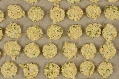 Parşömen kağıdına yerleştirilmiş çiğ soya köftelerinden oluşan, dokulu yüzeylerini ve görünür malzemelerini sergilemeye hazır bir kare.