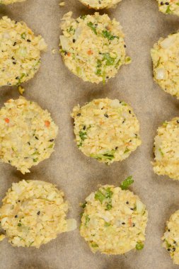 Parşömen kağıdına yerleştirilmiş çiğ soya köftelerinden oluşan, dokulu yüzeylerini ve görünür malzemelerini sergilemeye hazır bir kare.