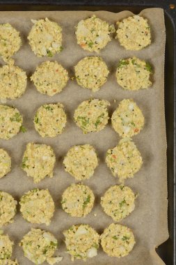 Parşömen kağıdına yerleştirilmiş çiğ soya köftelerinden oluşan, dokulu yüzeylerini ve görünür malzemelerini sergilemeye hazır bir kare.
