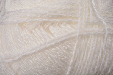 Beyaz ipliğin yakın plan çekimi, yumuşak dokusunu ve narin ipliklerini vurguluyor.