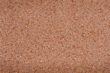 Yakın plan çekimde yoğun bir psyllium tohumu yığını görünür, oval şekilleri ve çeşitli kahverengi renkleri desenli, doğal bir desen oluşturur.