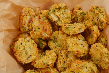 Kağıt kaplı bir kabın içinde altın-kahverengi renkleri ve kırsal dokuları sergilenen fırınlanmış soya köftelerinden oluşan tepeden tırnağa bir kare.