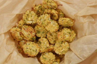 Kağıt kaplı bir kabın içinde altın-kahverengi renkleri ve kırsal dokuları sergilenen fırınlanmış soya köftelerinden oluşan tepeden tırnağa bir kare.