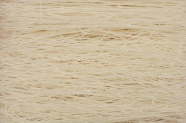 İnce, çiğ pirinç eriştesi demetinin düz bir görüntüsü ince dokularını ve ışıklarını ortaya çıkarıyor.