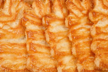 Palmier kurabiyelerinin yakın plan çekimleri, tuhaf tabakalarını ve karamelize yüzeylerini gözler önüne seriyor..
