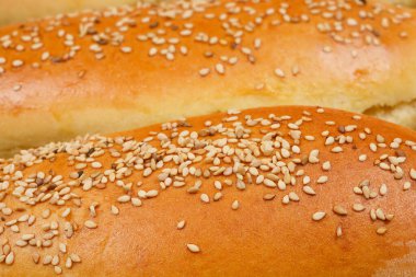Yakından çekilen hamur rulolarının üzerine susam tohumu serpiştirilmiş, altın-kahverengi kabuklarını gösteren
