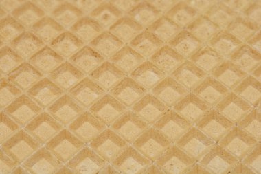 Bir gofret kağıdının detaylı elmas desenini ve açık kahverengi rengini vurgulayan yakın çekim, tam kare görüntüsü.