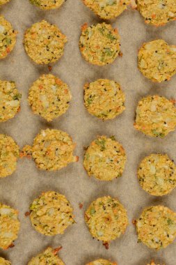 Parşömen kağıdına yerleştirilmiş fırınlanmış soya köfteleri, altın-kahverengi renklerini ve desenli yüzey dokusunu gözler önüne seriyor.