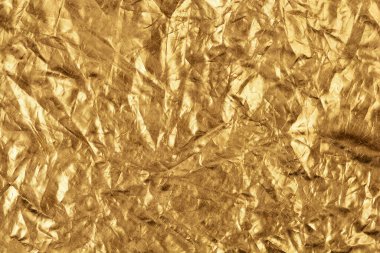 Yansıtıcı yüzeyini ve karmaşık kıvrımlarını gösteren buruşmuş altın folyonun yakın çekim dokusu.