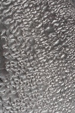 Küçük su damlacıklarıyla kaplı metal bir yüzeyi yakından çekerek desenli bir desen oluşturur.