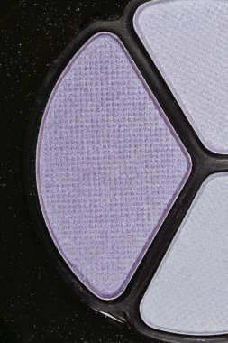 Mor ve gri tonları olan bir göz farı paletinin yakın çekimi.