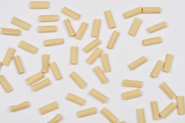 Dağınık kahverengi kağıt parçaları beyaz bir arkaplan üzerine dizilmiştir