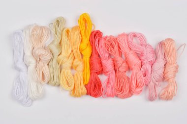 Renkli nakışlı diş ipleri beyaz arka planda düzdür.