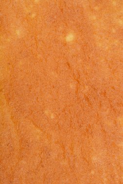 Fırında pişmiş bir kek katmanının yakın çekim, dokulu bir yüzeyi, sıcak, altın-kahverengi rengini ve narin desenlerini sergiliyor, rulo kek tabanı için mükemmel.