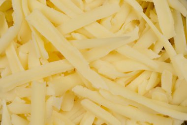 Görüntü dilimlenmiş Gouda peynirinin yakın çekimini gösteriyor.