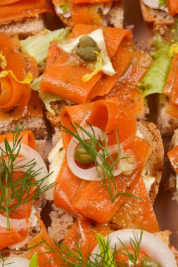 Açık yüzlü sandviç çeşitleri. Açık bir kabın içinde, vejetaryen somon gibi hazırlanmış havuç dilimleri.