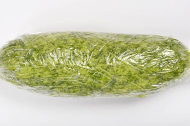 Sıkıca sarılmış yeşil sarımsak (Allium ursinum) yağı düz, açık renkli bir yüzey üzerinde dikey olarak sunulur.
