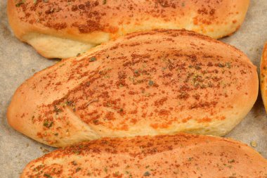 Birkaç altın sarısı sarımsak ve kekik sarımsağı, parşömen kağıdıyla kaplanmış bir tavaya konur.