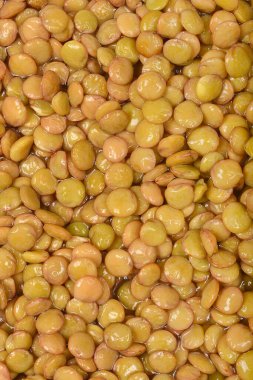 Yakın plan, pürüzsüz, hafif parlak dokuya sahip yoğun ve sulandırılmış çiğ mercimek yığınını gösteriyor.