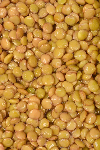 Yakın plan, pürüzsüz, hafif parlak dokuya sahip yoğun ve sulandırılmış çiğ mercimek yığınını gösteriyor.