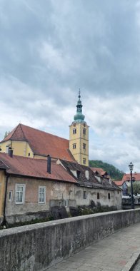 Samobor 'daki St. Anastasia Kilisesi' nin kendine özgü kulesi ve bulutlu gökyüzünün altındaki binaları.