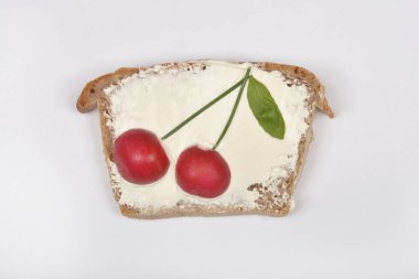 Frenk soğanı saplı iki turp ve bir fesleğen yaprağı, krem peynirle yayılmış bir dilim kiraz üzerine serpiştirilmiş, sade beyaz bir zemin üzerine serpiştirilmiş kiraz gibi şakır şakır düzenlenir.