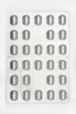 Tarafsız bir geçmişe karşı gümüş oval hap paketleri aşağı bakış, ilaç, sağlık ve ilaç öneriyor