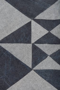 Açık ve koyu mavi kot parçalarından oluşan desenli bir yama geometrik elmas ve üçgen deseni oluşturur.