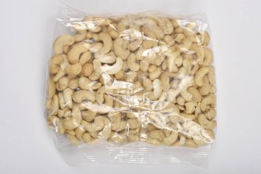 Beyaz bir yüzeyde içi ceviz dolu temiz bir plastik torba sergilenir.